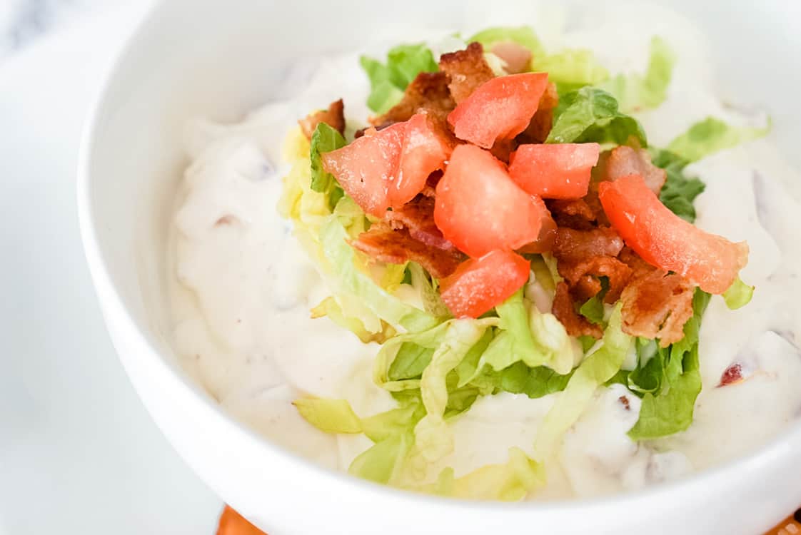closeup of bacon lettuce and tomato dip in a white bowl