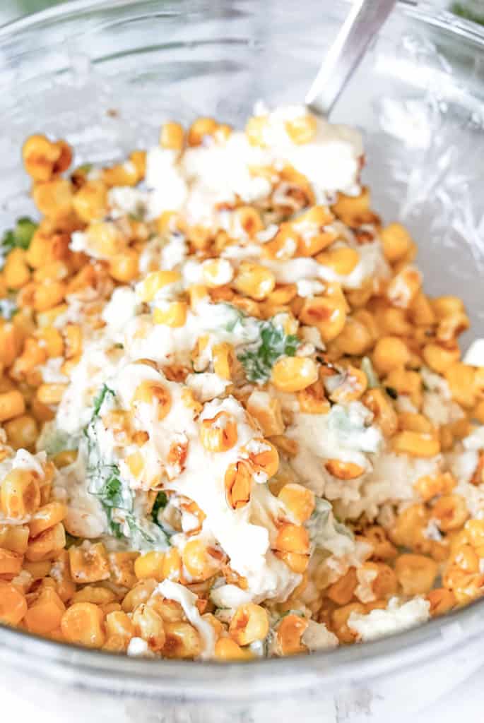 mixed up elote dip in a clear glass bowl