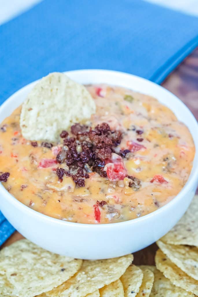 prepared rotel dip with cooked sausage and a tortilla chip garnish