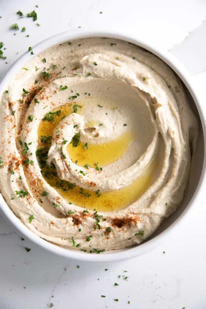 homemade hummus dip in a bowl with olive oil drizzle