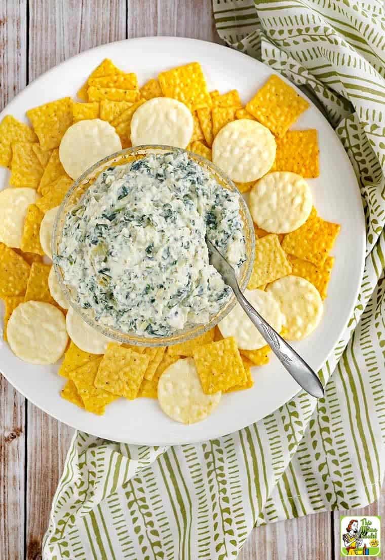 overhead photo of vegan spinach artichoke dip with vegan crackers on these side