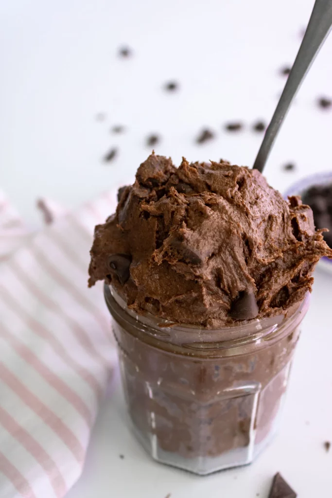 closeup of edible brownie dip in a jar with a spoon