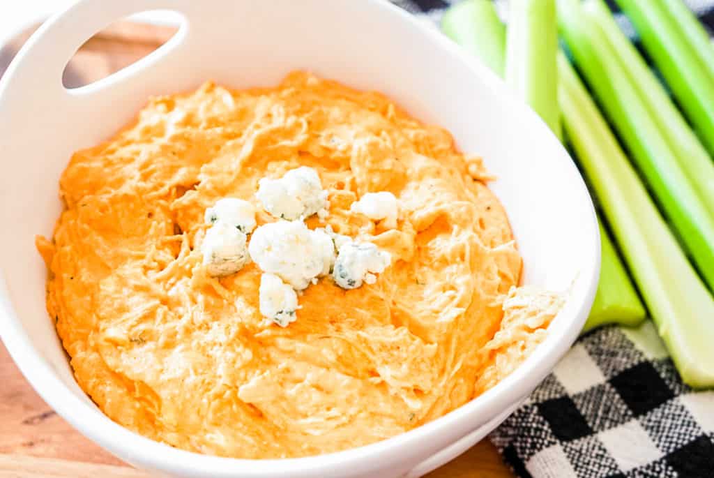 prepared franks red hot buffalo chuicken dip in a white bowl with celery on the side