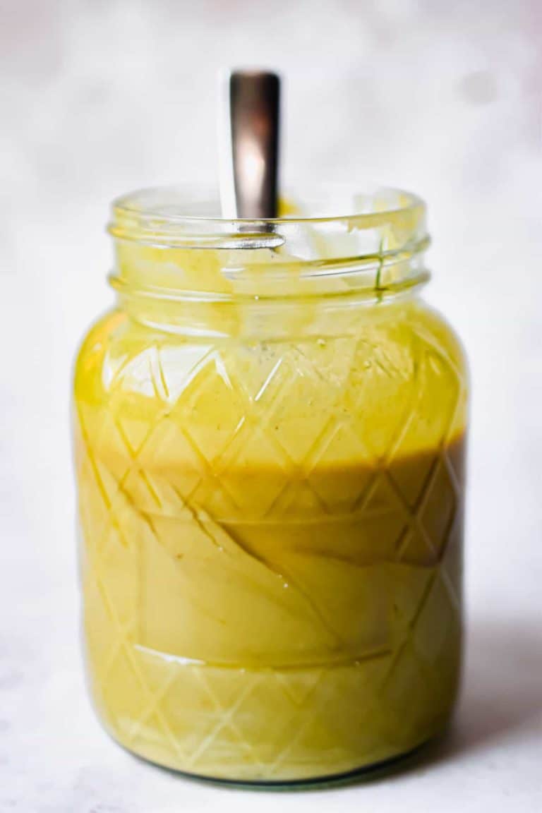 homemade honey mustard in a mason jar with a spoon sticking out