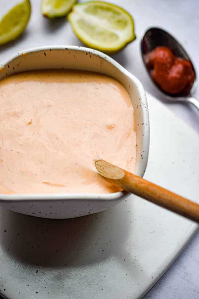 sriracha aioli in a bowl with a wooden spoon