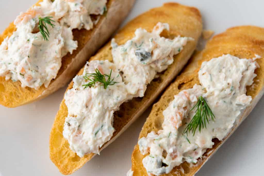 smoked salmon dip with cream cheese spread on sliced toasted baguette