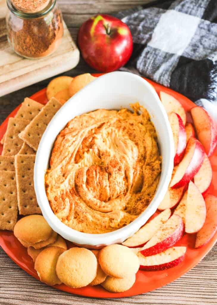 easy pumpkin dip in a white bowl with dippers on the side