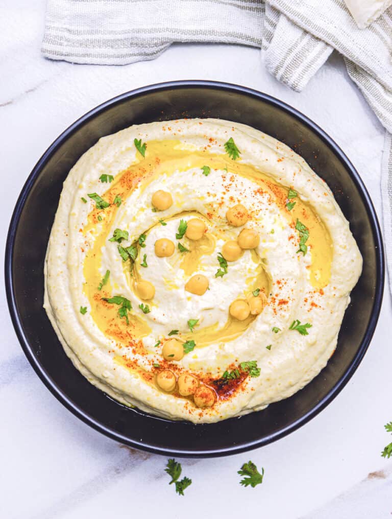 photo of classic hummus with chickpeas and olive oil drizzle