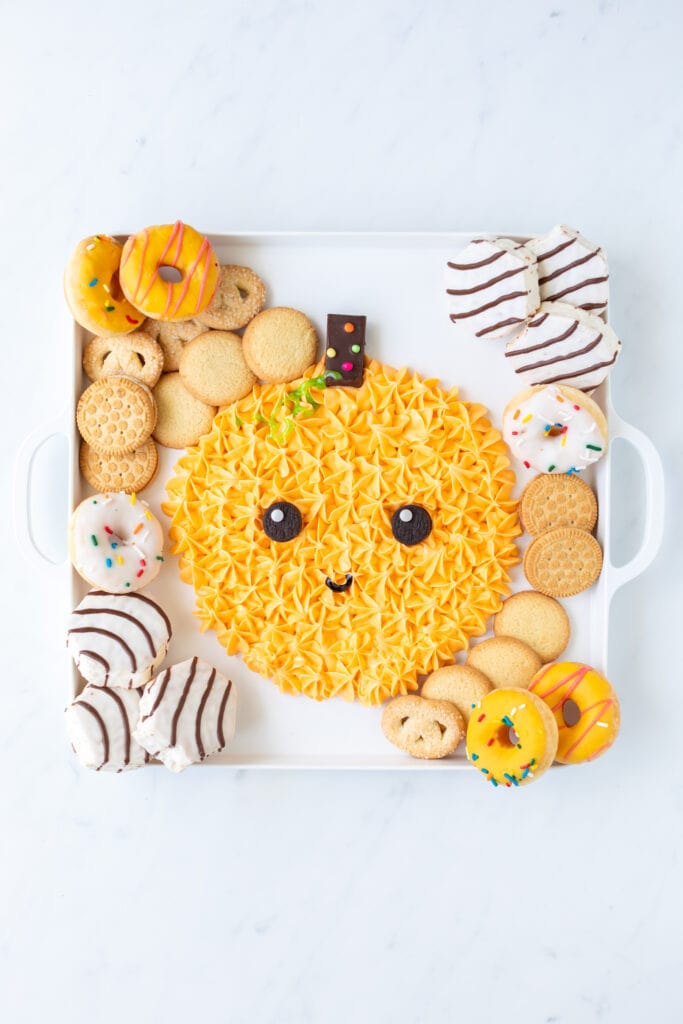 zebra cakes and other goodies on pumpkin Halloween frosting board