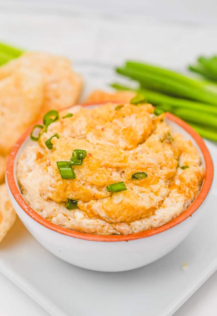 prepared warm crab rangoon dip in a bowl garnished with green onions