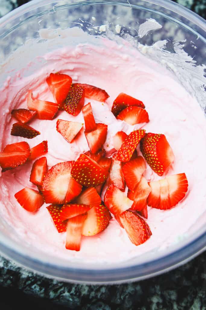 fresh diced strawberried and pink strawberry fruit dip in a bowl