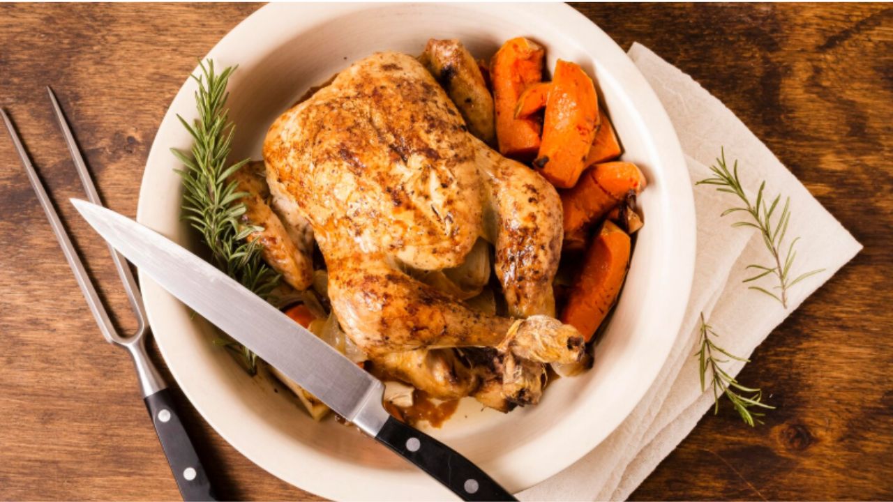 Top view of plate with thanksgiving roasted chicken and cutlery
