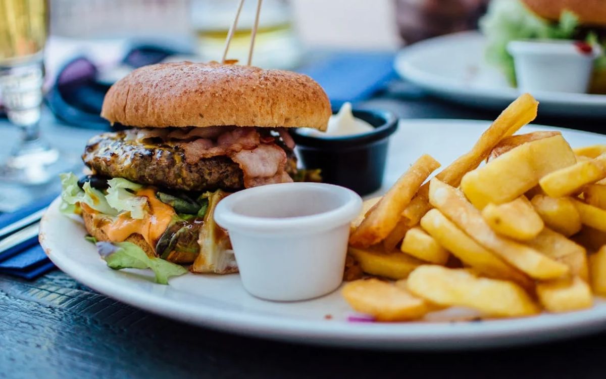 Burger with fries served on a white plate
