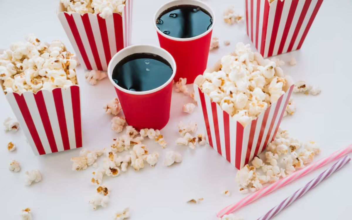 Popcorn in striped boxes with soft drinks in red cups