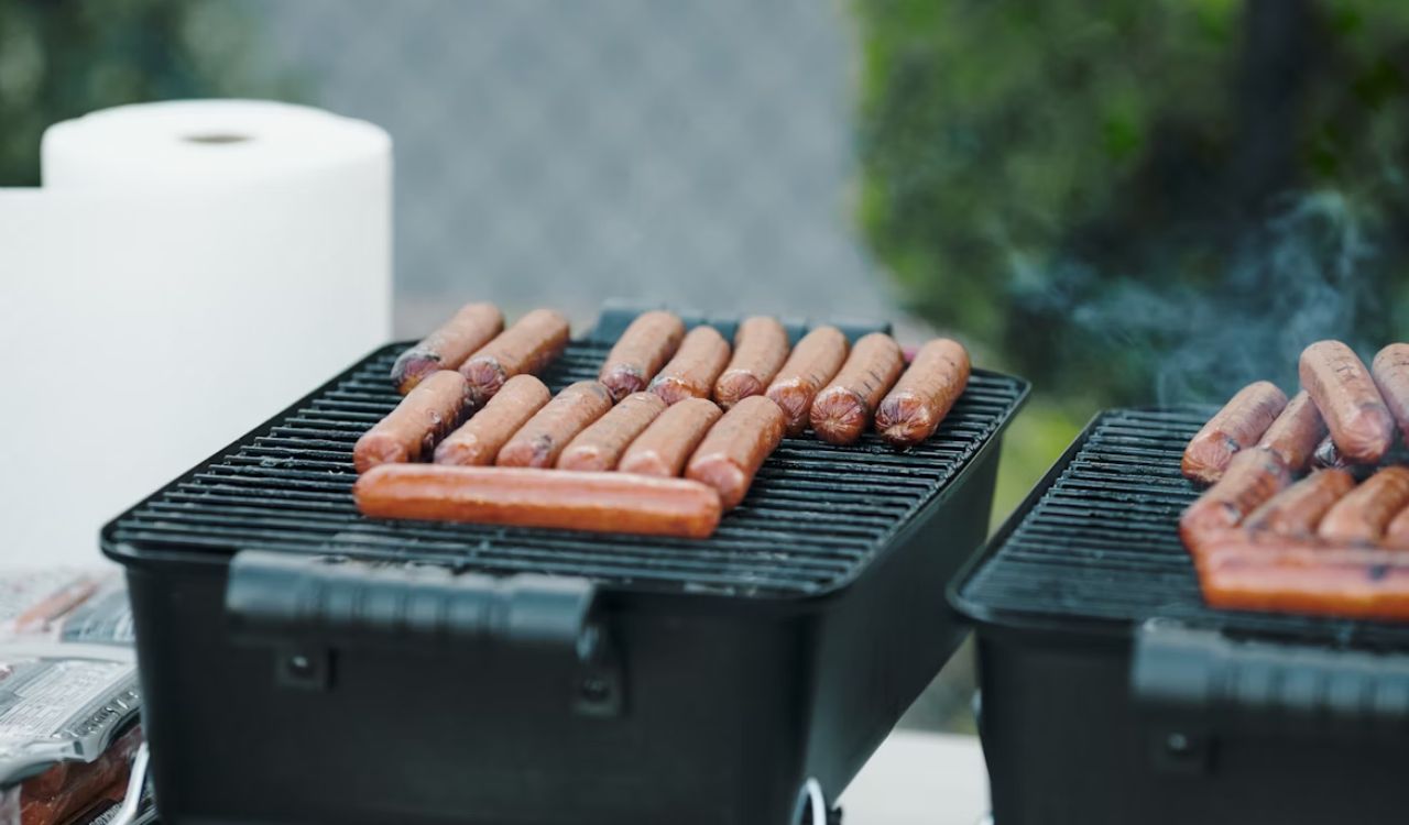A couple of grills that have some hotdogs on them