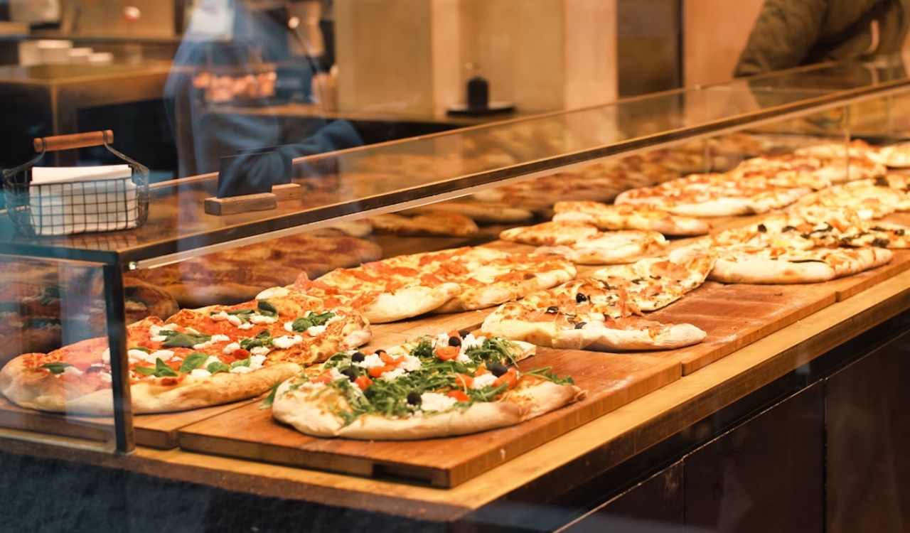 A display case filled with lots of pizzas