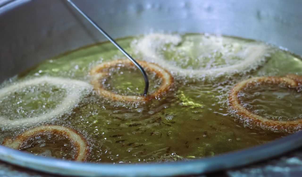 A frying pan filled with oil and onion rings