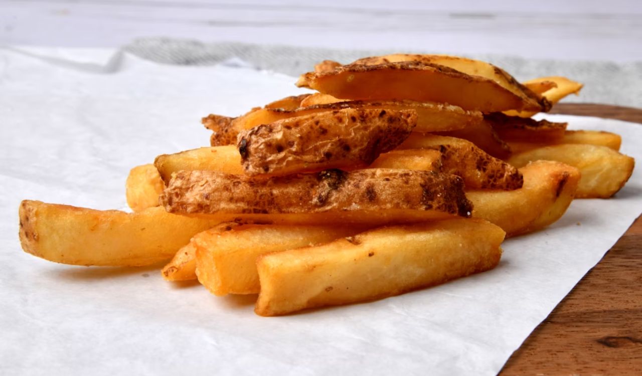 A pile of French fries sitting on top of a white paper