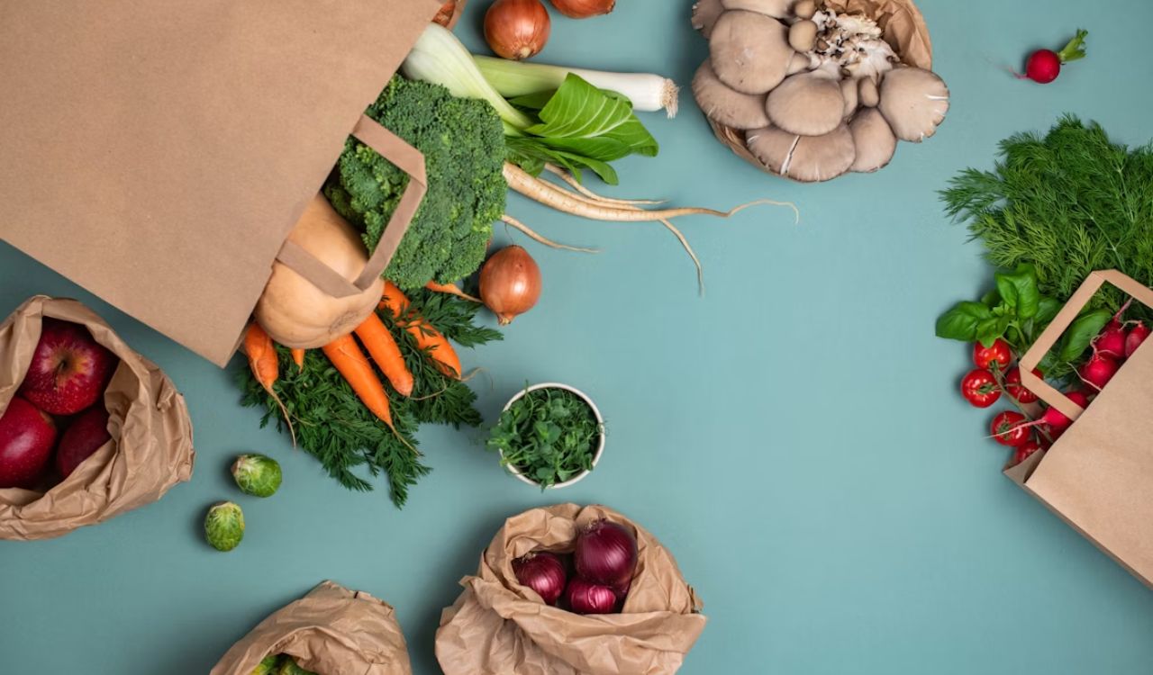 A table topped with bags filled with different types of vegetables