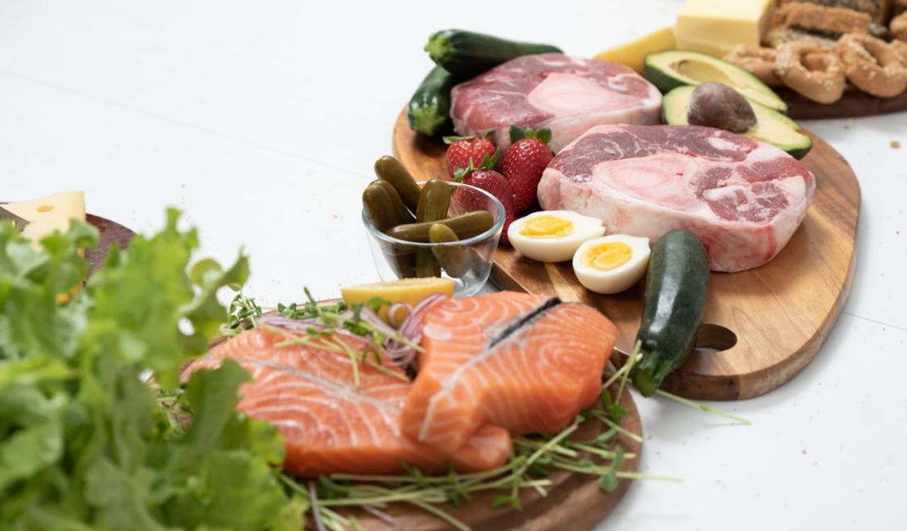 Assorted Fresh Meat and Salmon with Fruits and Vegetables on a Chopping Board