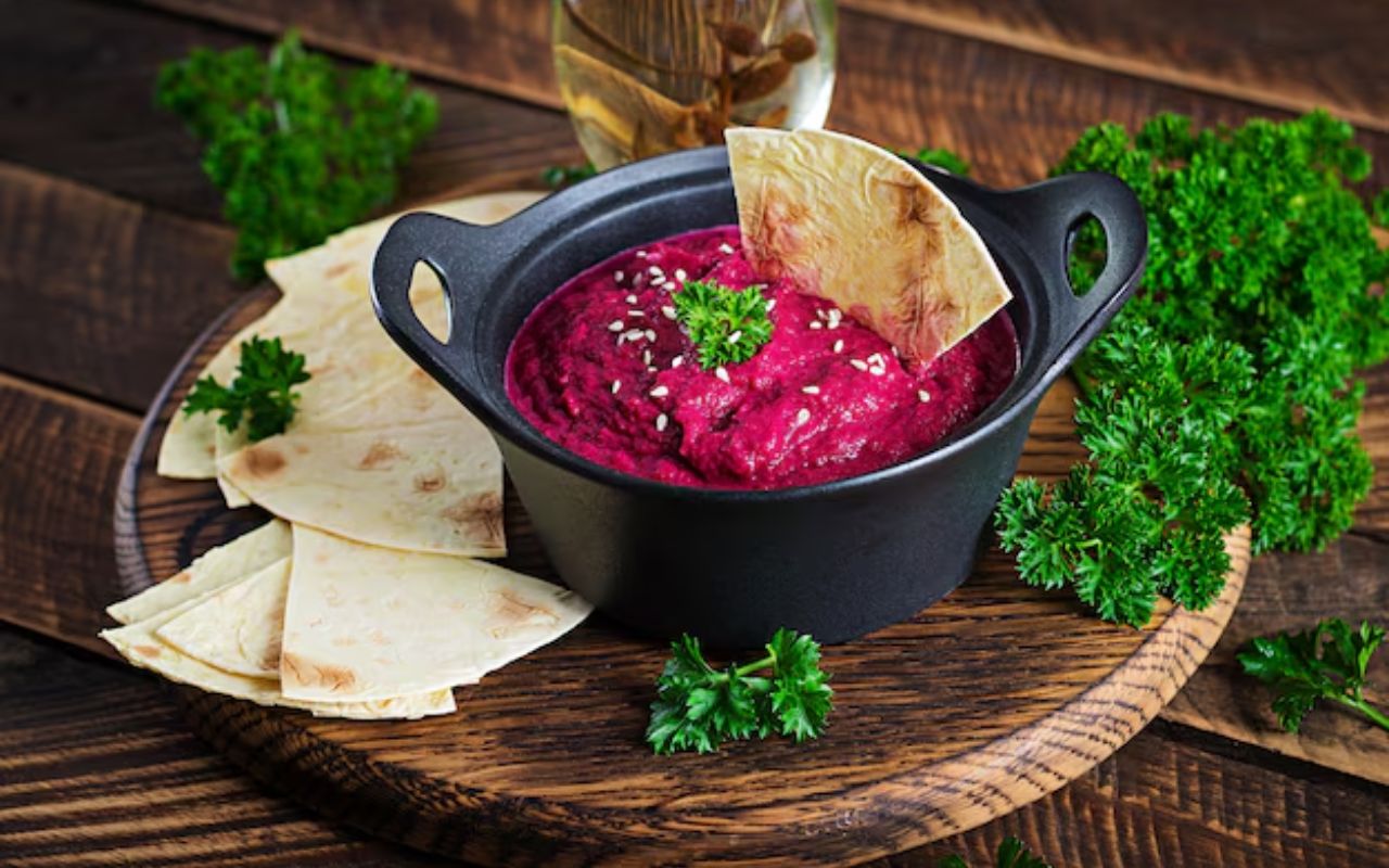 Beet hummus with pita bread and parsley garnish