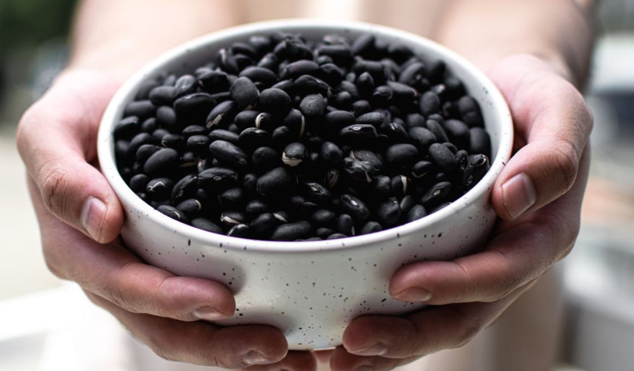 Close-up of Hands Holding Bowl of Black Beans