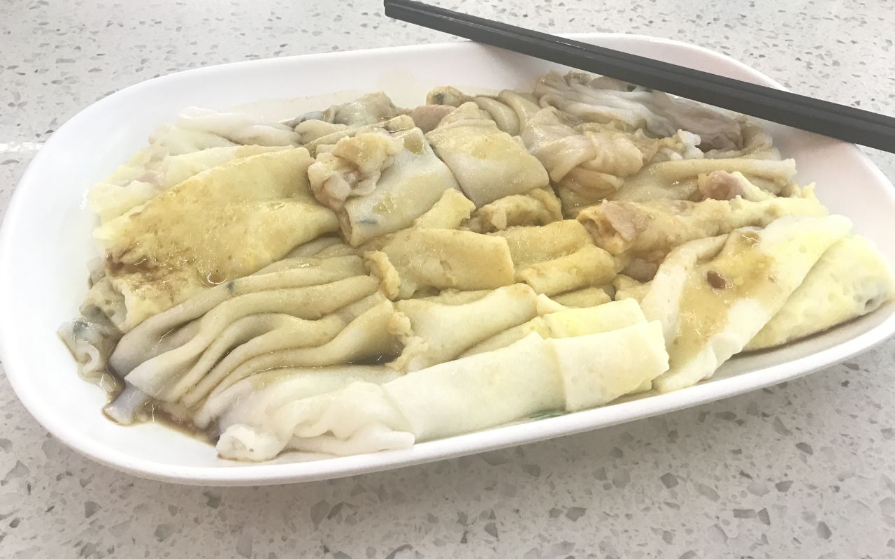 Cheong fun rice noodle rolls on a plate with chopsticks