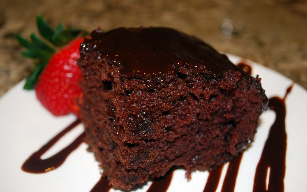 Slice of chocolate cake with ganache and strawberries