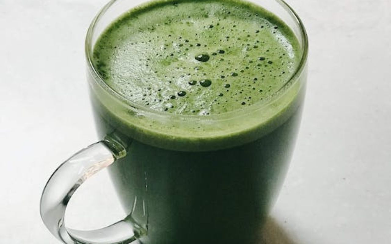 A green coffee avocado milkshake in a glass cup