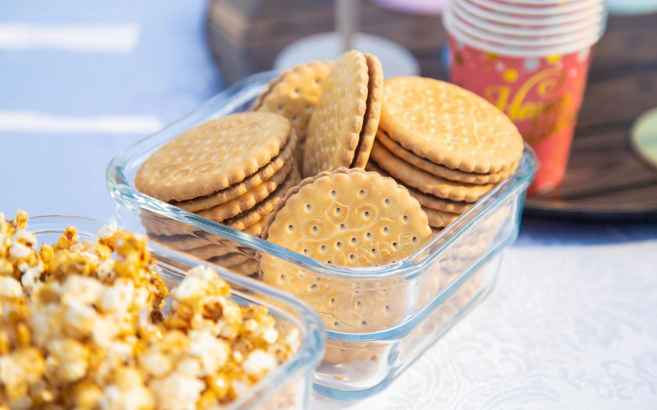 Biscuits in a glass container with caramel popcorn in foreground