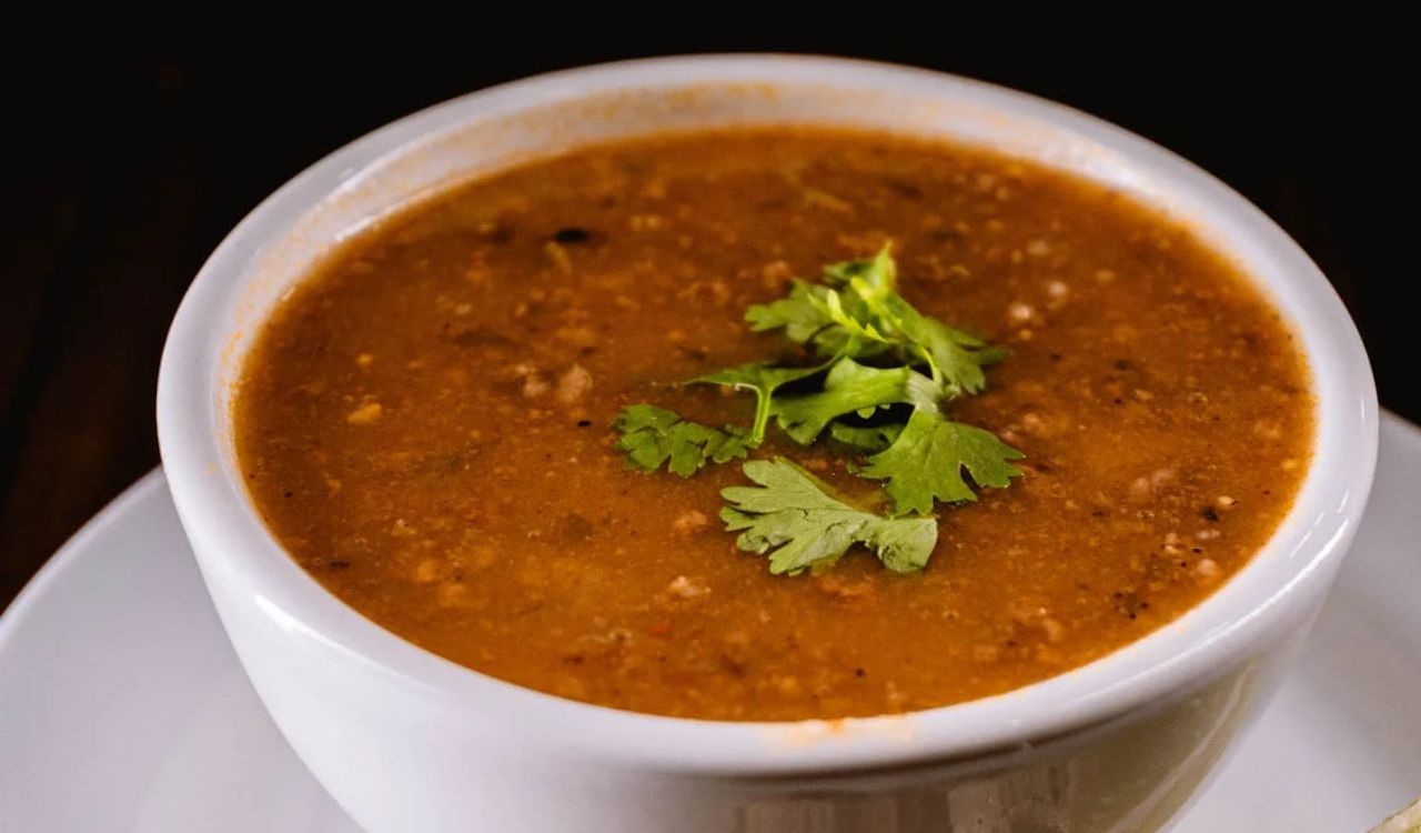 Delicious Bowl of Lentil Soup Garnished with Fresh Herbs