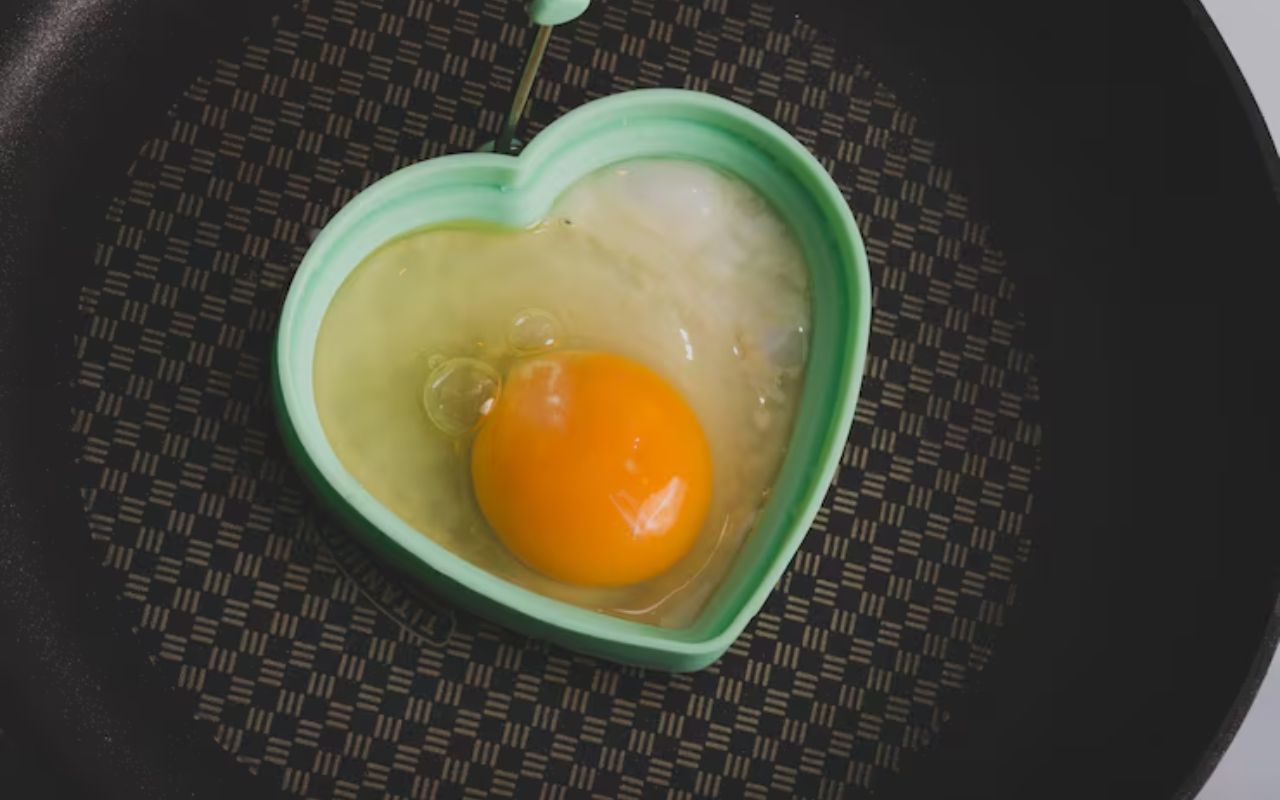 Egg in heart-shaped mold on pan