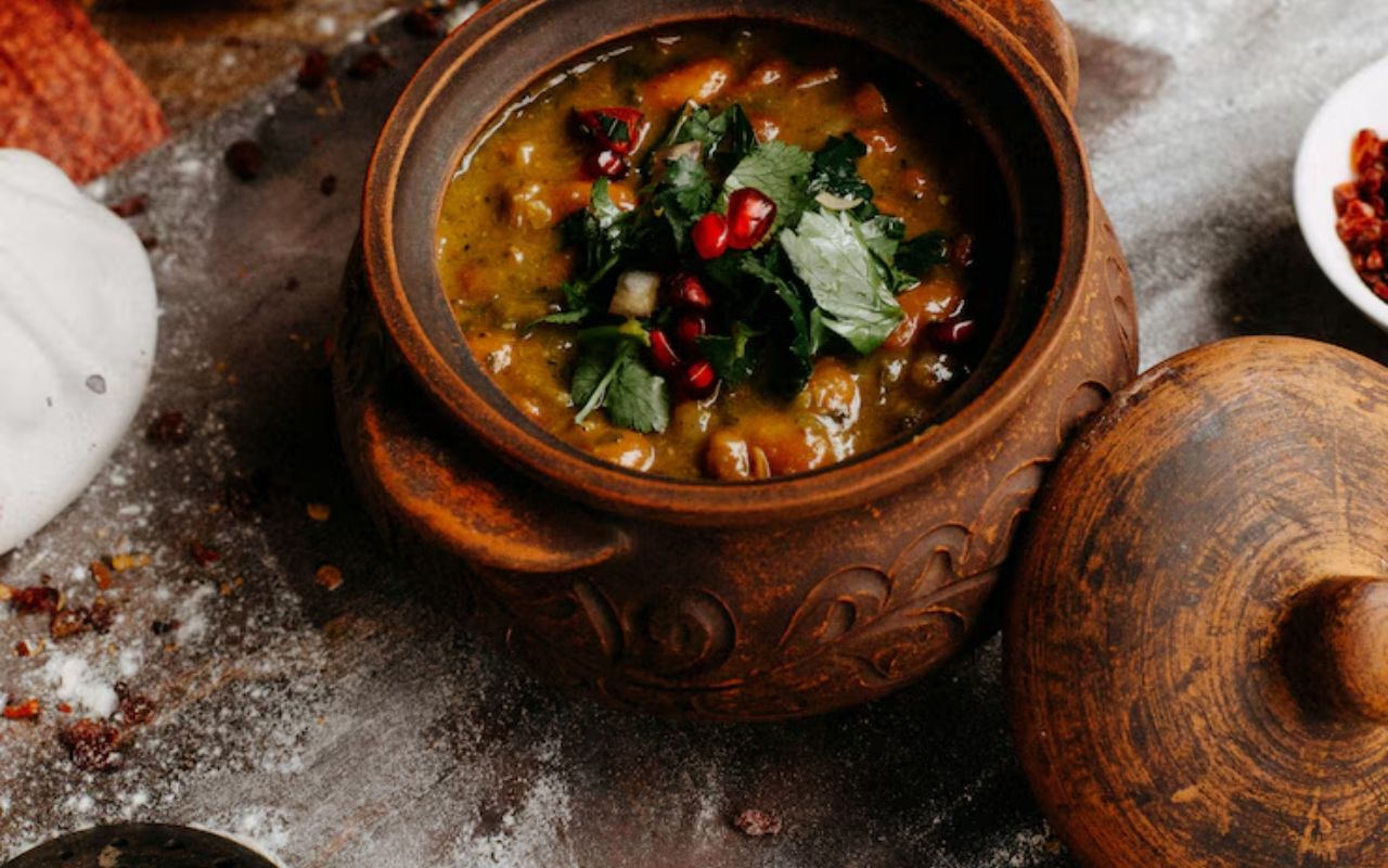 Clay pot of chili topped with herbs