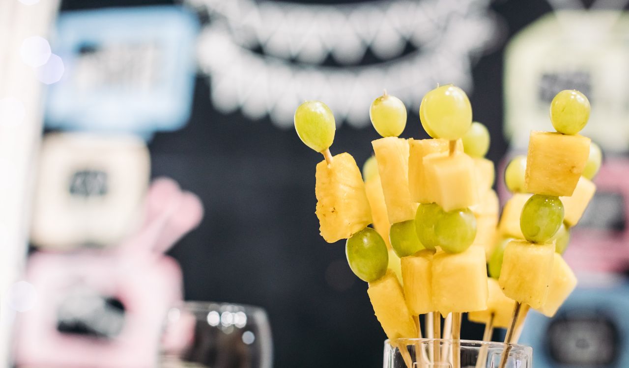 Tasty canapes with cheese and green grapes in glass