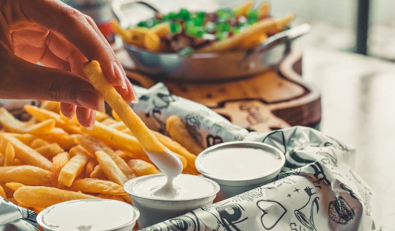Hand with Fries in Sauce