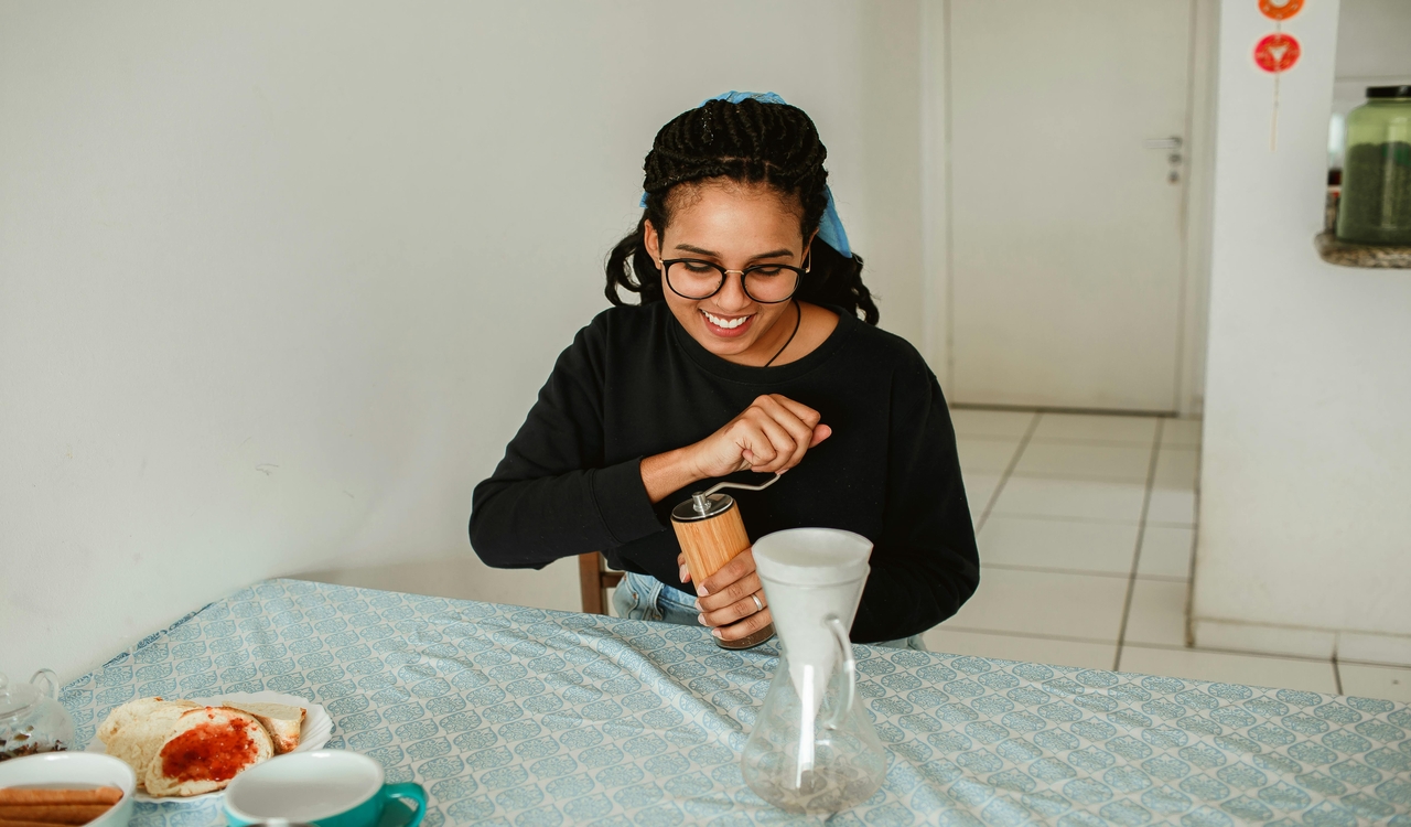 Woman in Black Long Sleeve Shirt Using a Coffee Grinder