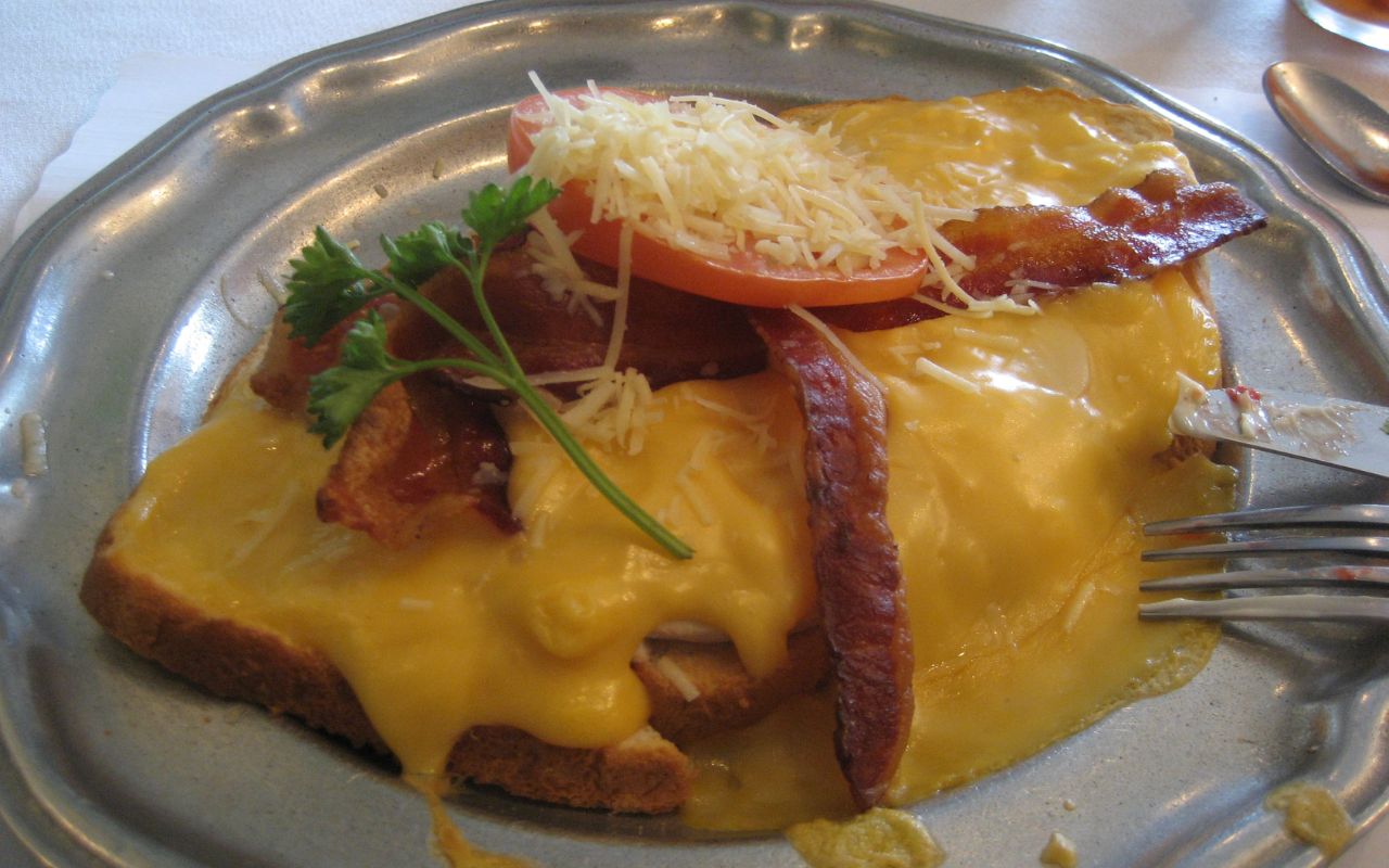 Hot Brown sandwich with bacon, tomato, and melted cheese
