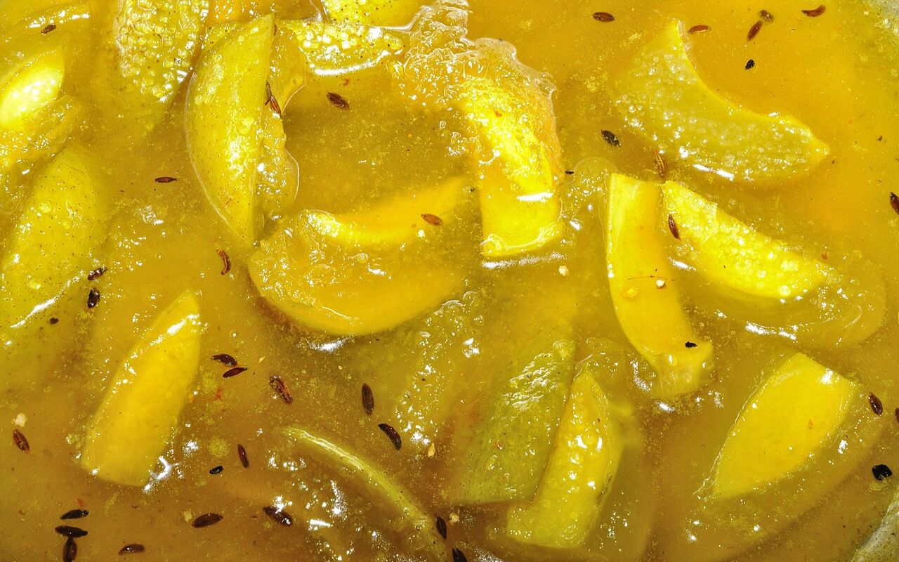 A bowl of mango chutney with sliced mangoes and spices