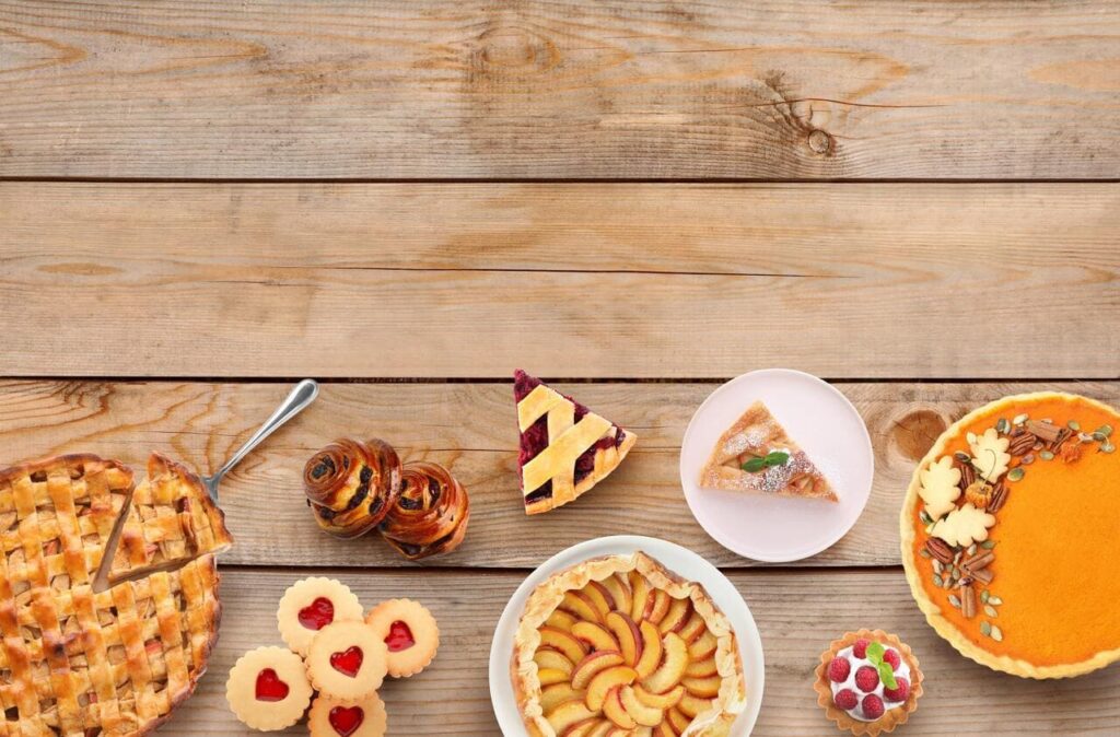 Many different delicious pies on wooden table, flat lay.