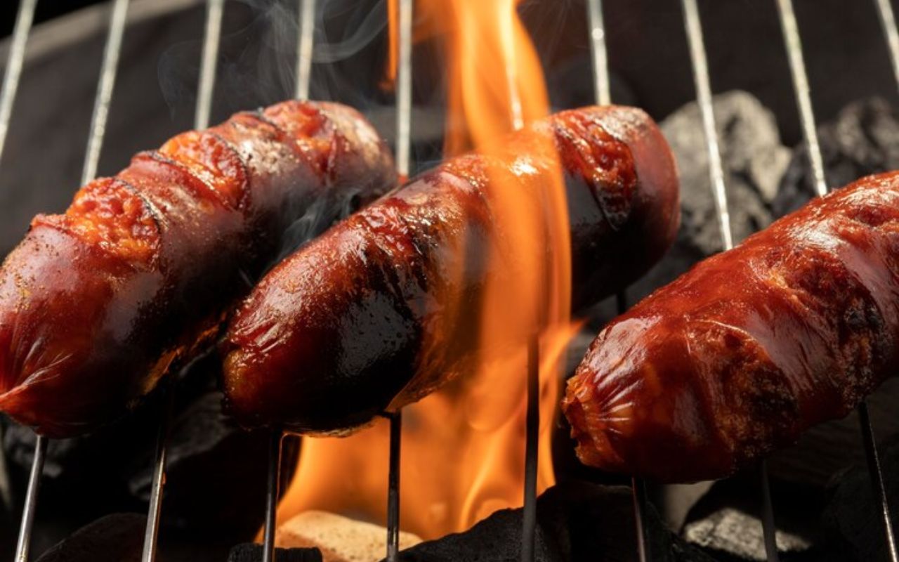 Sausages grilling over open flames