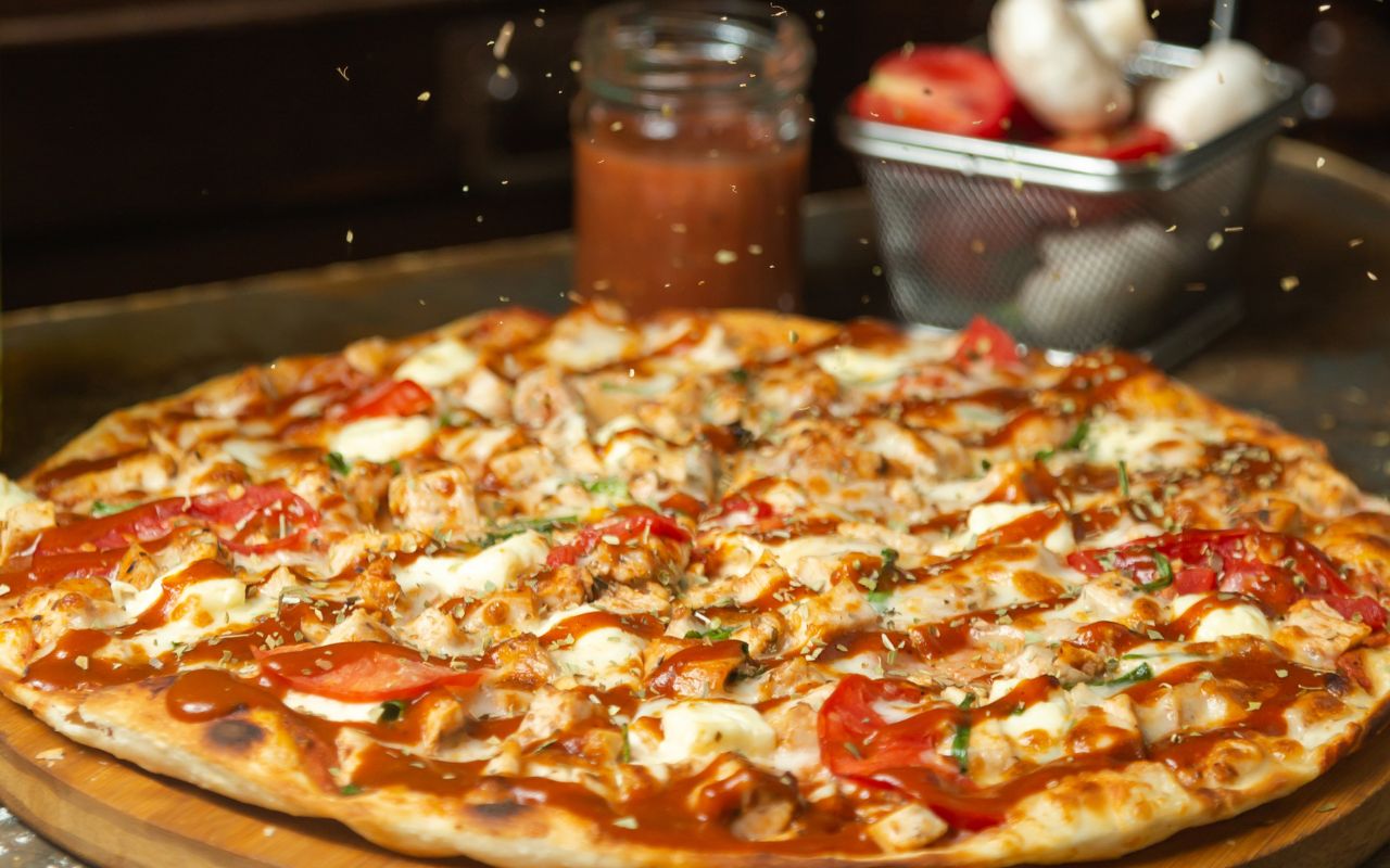 New York-style pizza topped with cheese, tomatoes, and herbs