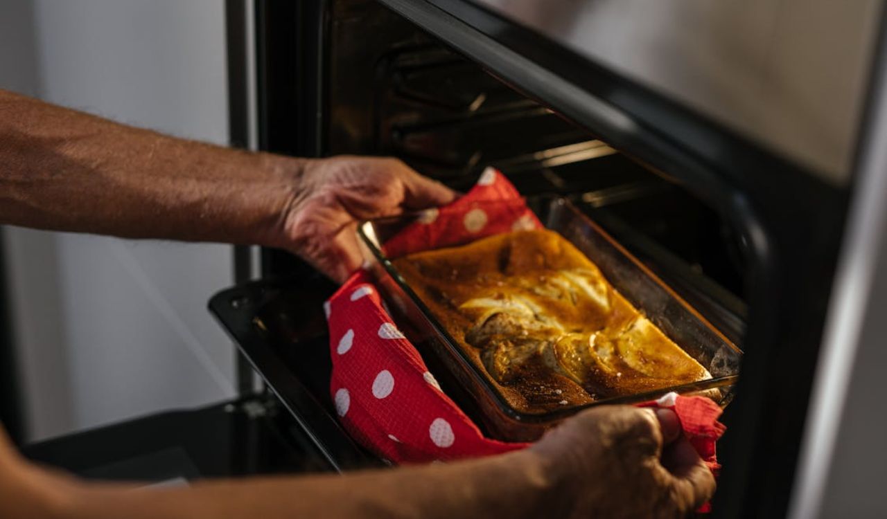 Person Taking Out Cake into Oven