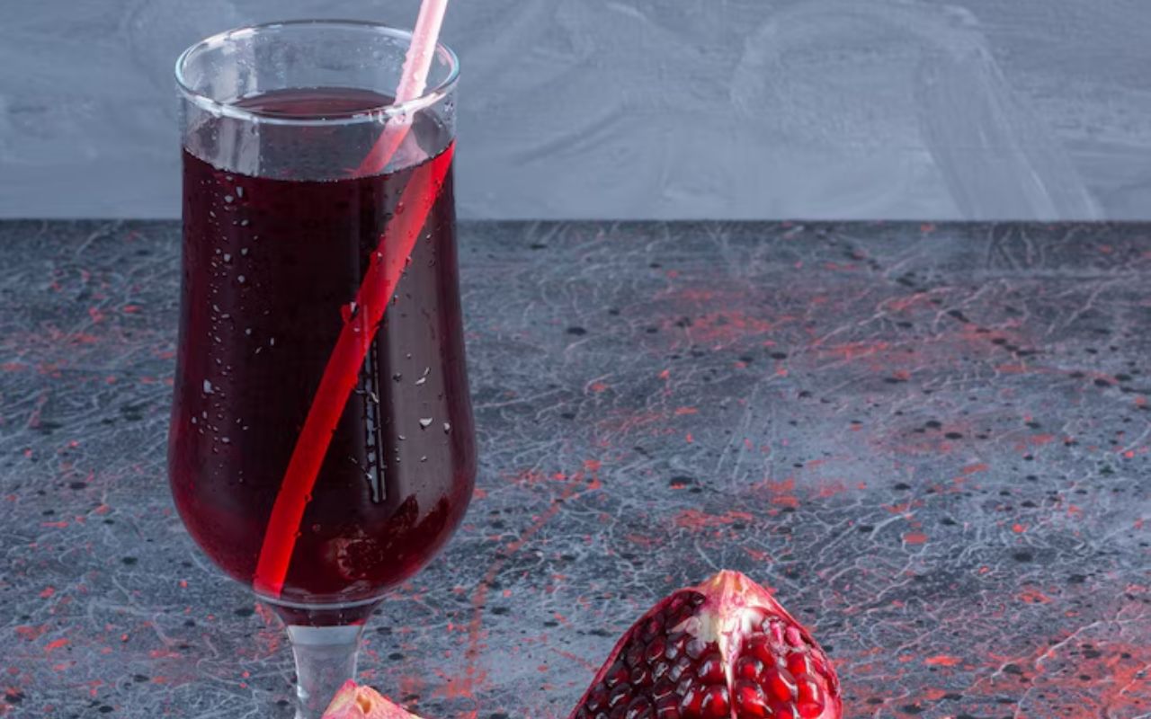 Pomegranate cocktail in a stemmed glass with straw