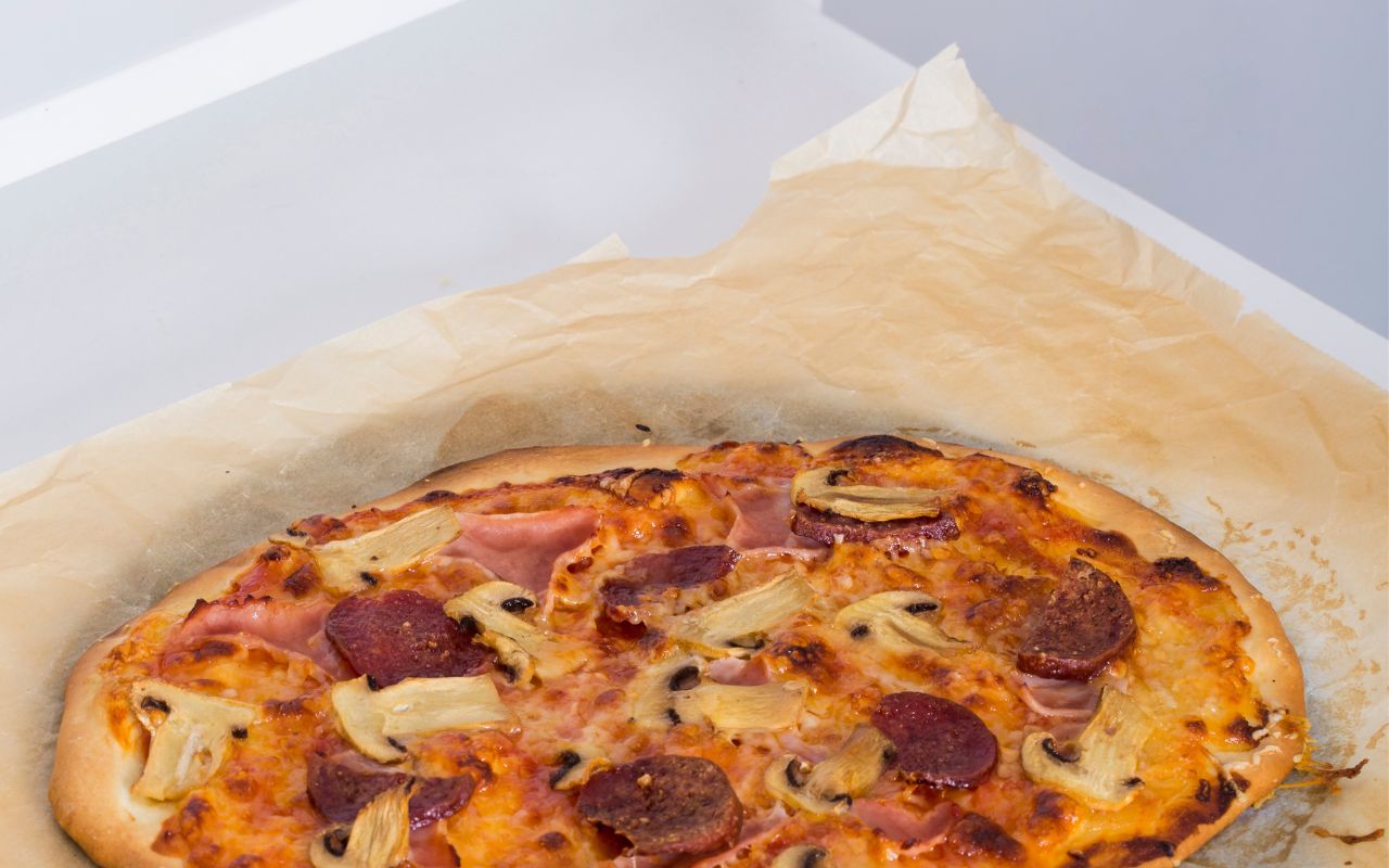 Baked pepperoni-mushroom pizza on parchment paper