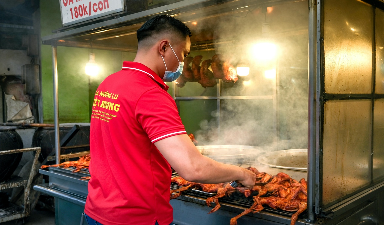 A Man in a Red Polo Shirt Grilling Chicken