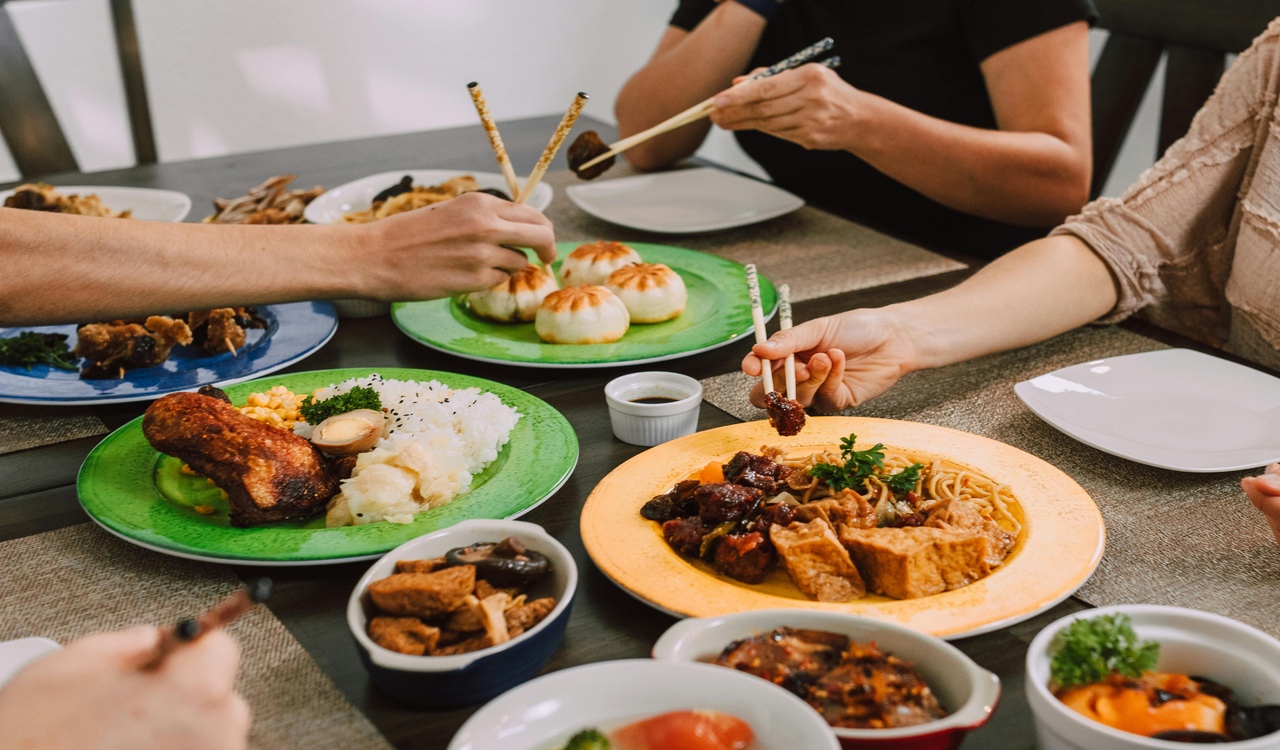 People Eating Food on the Plates Using Chopsticks
