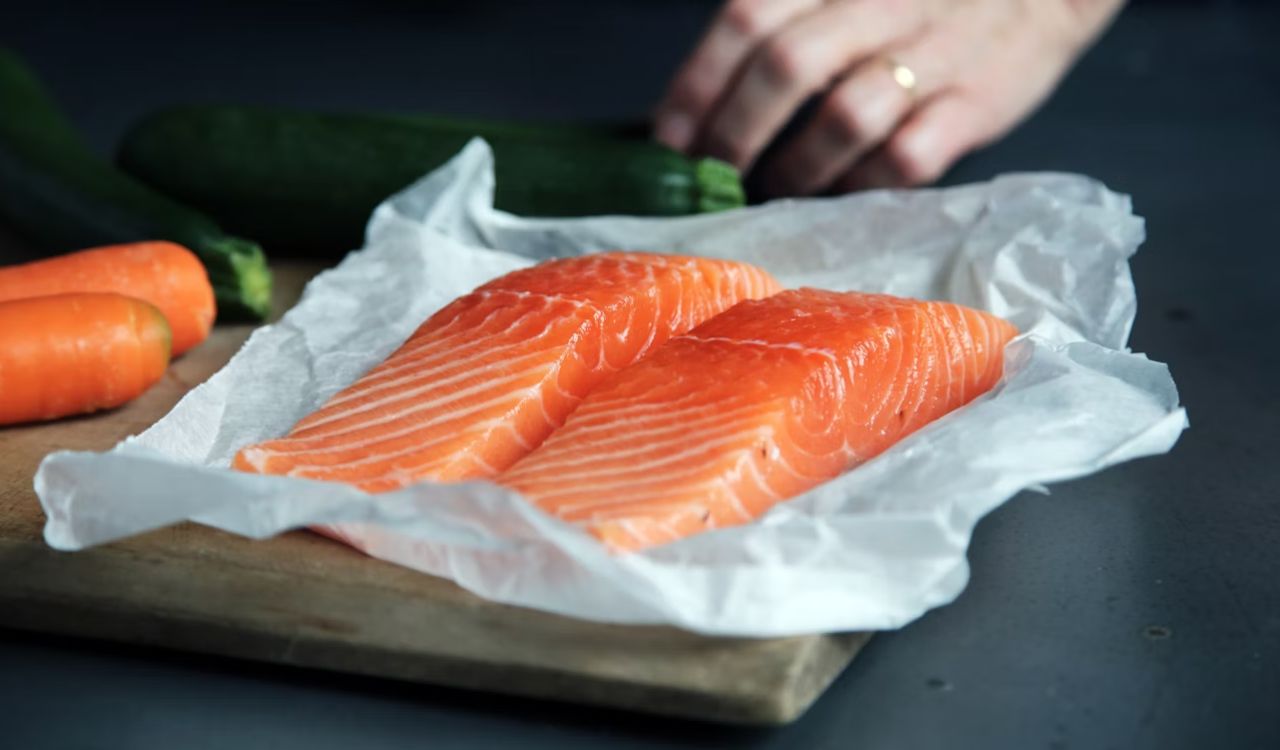 Raw salmon on brown chopping board