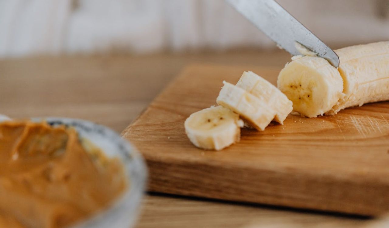 Slicing of Banana on Wooden Chopping Board