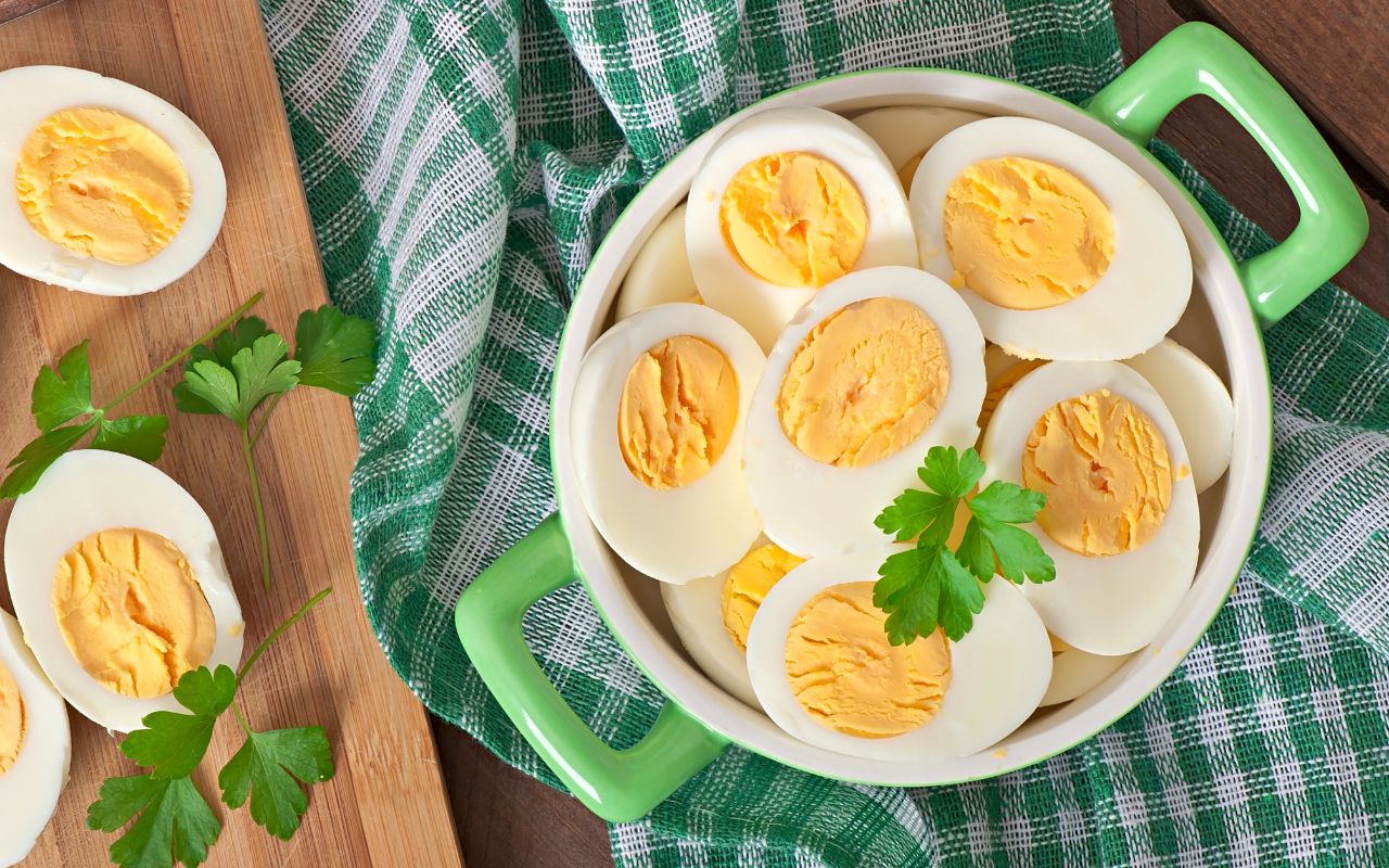 Halved boiled eggs in a bowl with parsley