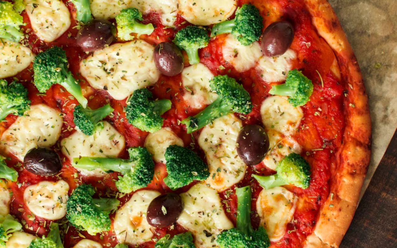 Pizza topped with broccoli, olives, and cheese